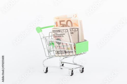American dollars and fifty euro in the shopping push cart, isolated