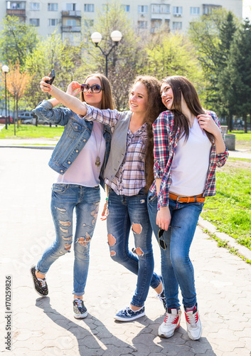 Happy teenage girls hawing fun spend time together in the city park © lkoimages