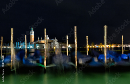 Gondolas anchored on Grand Canal in Venice - long exposure night shot with motion blurred gondolas