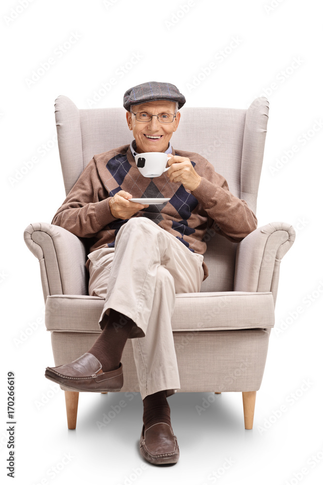 Senior sitting in an armchair and having a cup of tea