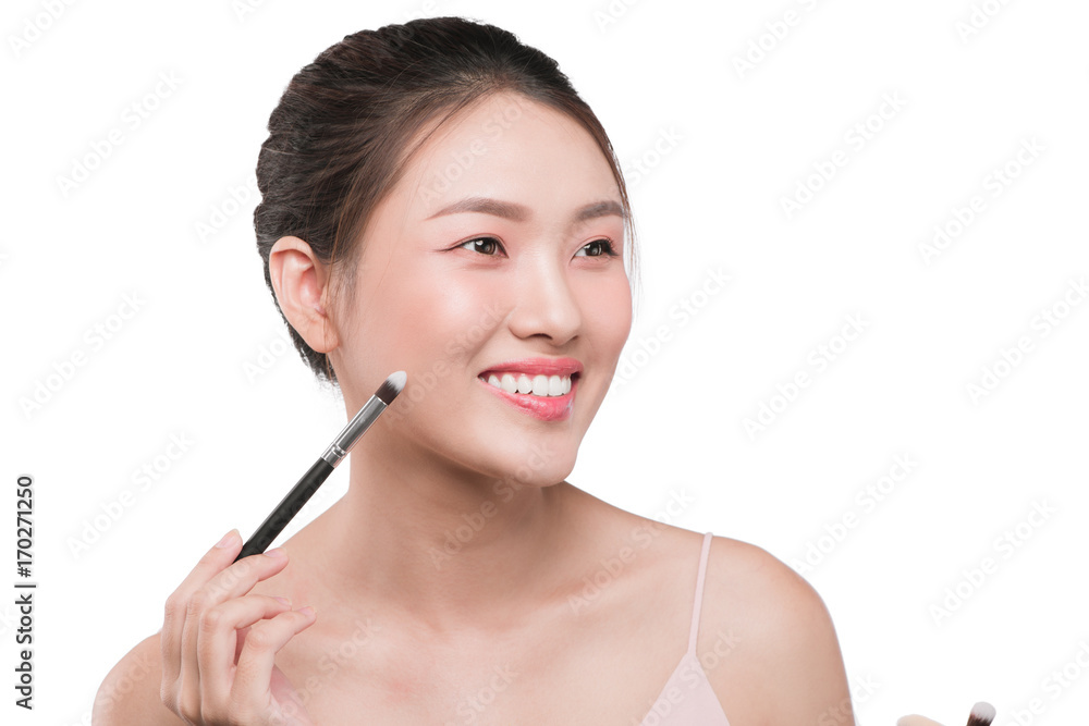Portrait of attractive young asian woman holding make-up brushs over white Portrait of attractive young asian woman holding make-up brushs over white