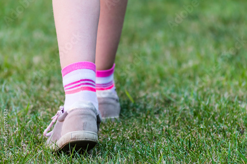 Footstep of young girl on green field
