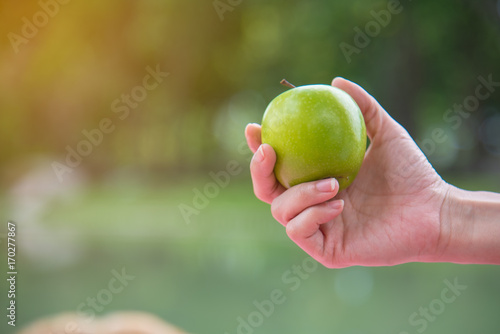 Closeup of green apple in healthy woman hand. Healthy fruit. Vegetarian. Wellness. Health and food concept.