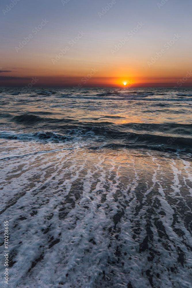 Sunrise near the sea beach with blue waves