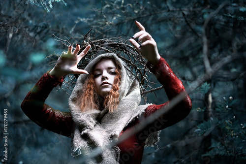 Obraz na plátně Red-haired witch in a dense forest