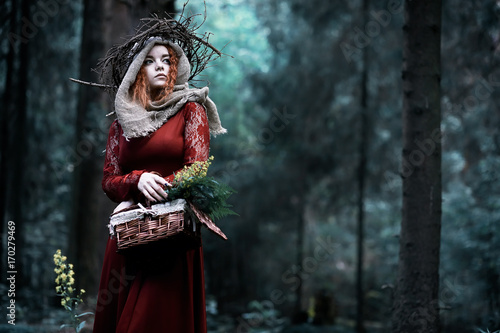 Red-haired witch in a dense forest © alexkich
