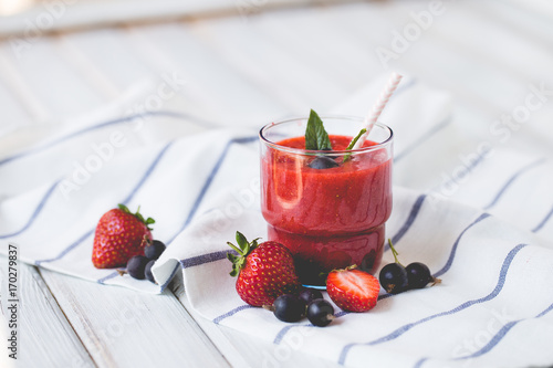 Smoothies of black currant and strawberries with yogurt on a white wooden table. photo