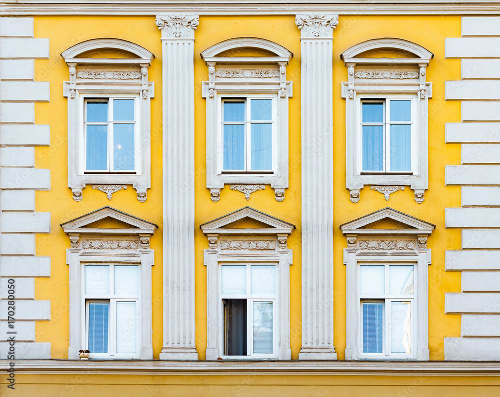 Facade of antique historical building. Windows with decorative stucco elements. Lviv, Ukraine. European travel photo.