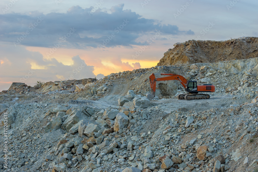 The tracked excavator is parked in the stone quarry after work until the twilight time. The tracked excavator is parked in the stone quarry after work until the twilight time.
