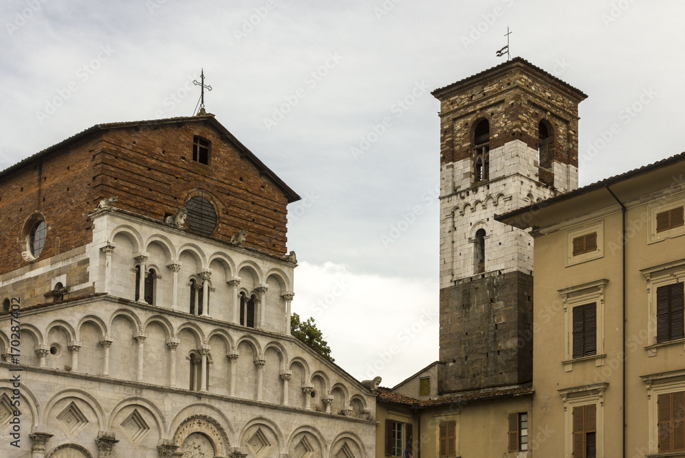 Facade of Santa Maria Forisportam church and bell tower in Lucca, Italy