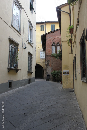 Fototapeta Naklejka Na Ścianę i Meble -  Narrow street in Lucca city centre, Tuscany, nobody around