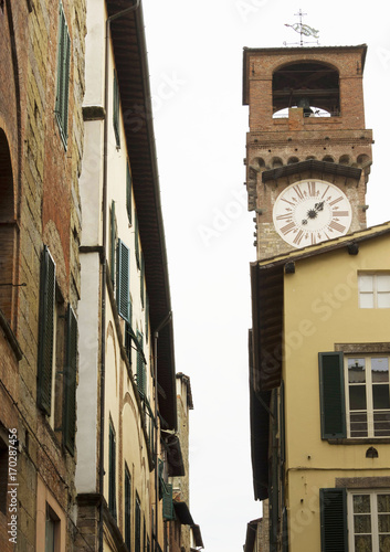 Tower clock in Lucca through buildings