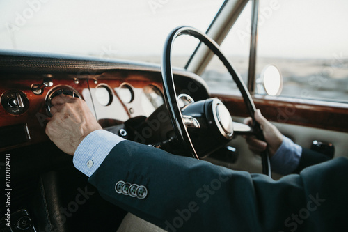inside view of classic luxury car being driven by man.
