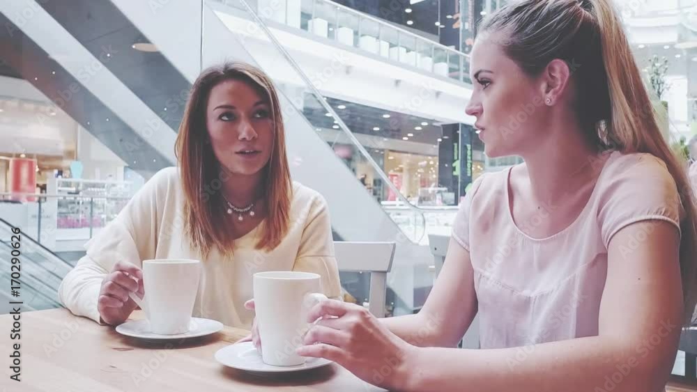 Meeting of friends woman talking in cafe at shopping mall Meeting of friends woman talking in cafe at shopping mall