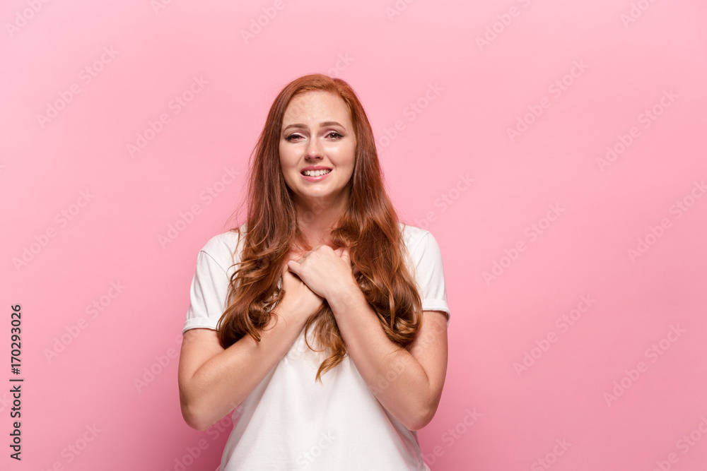 Naklejka premium The beautiful woman is offended on pink studio