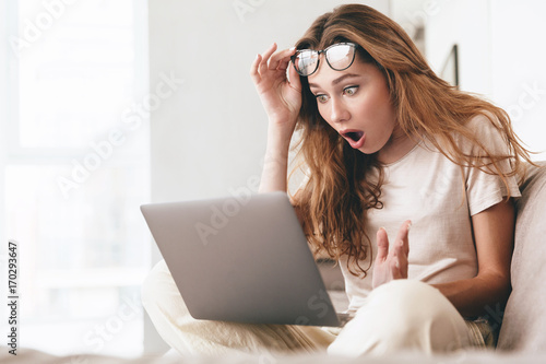 Foto Shocked lady using laptop computer.