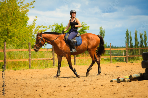 Jockey girl doing horse riding on countryside meadow © Voyagerix