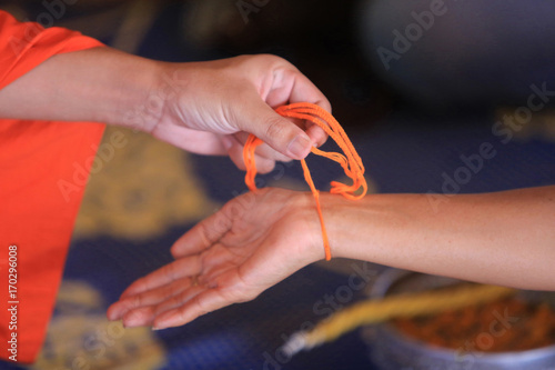 Sa• Sin. Bracelet en coton symbolisant le lien sacré. Cérémonie bouddhiste. Wat Simuong. Wat Si Muang. Vientiane. Laos. photo