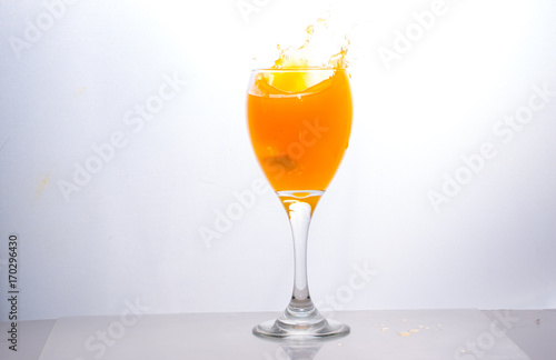 Orange juice splashing out of glass., Isolated white background.