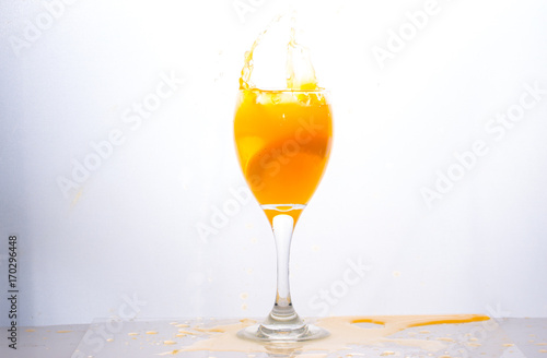Orange juice splashing out of glass., Isolated white background.