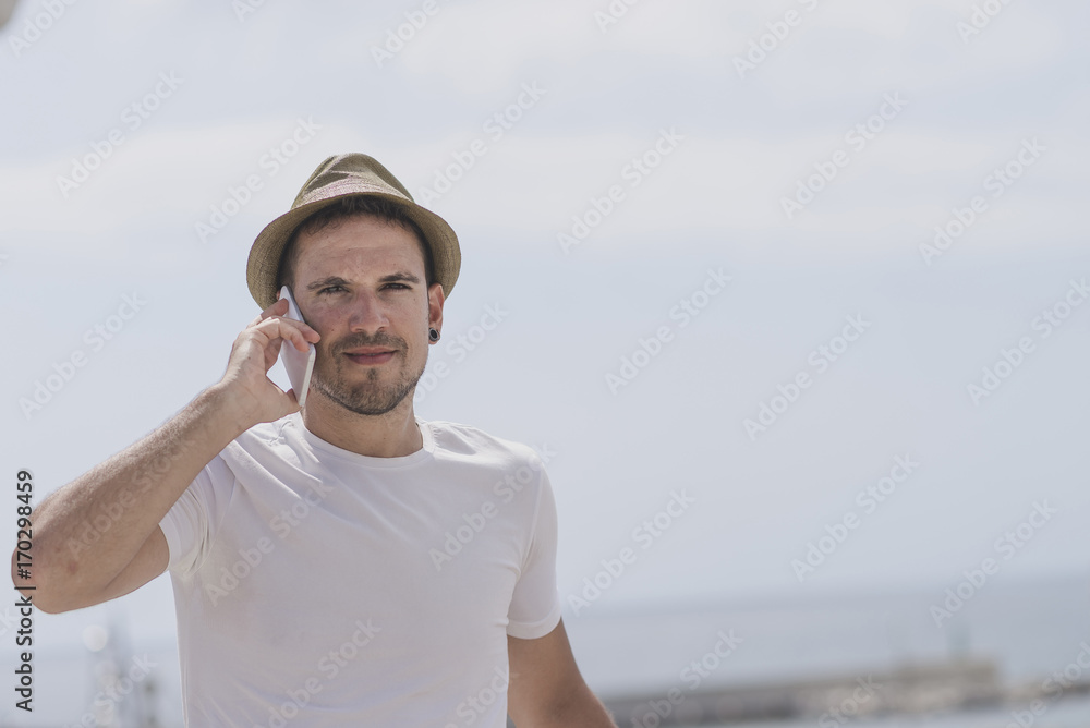 Portrait of a happy businessman walking outdoors with mobile pho