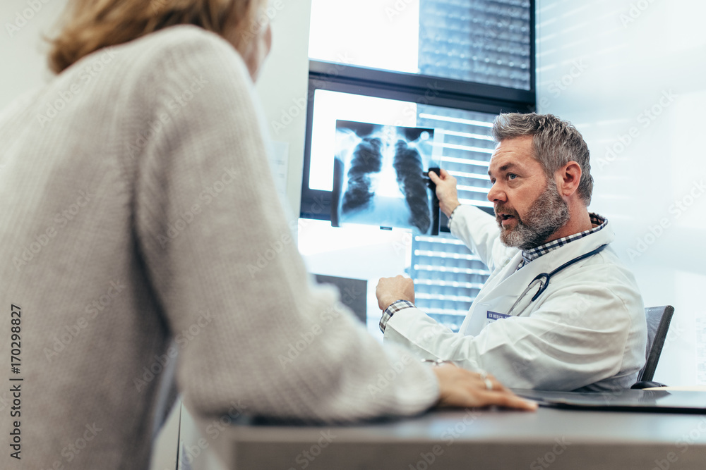 Fototapeta premium Doctor showing x-ray to his patient in medical office