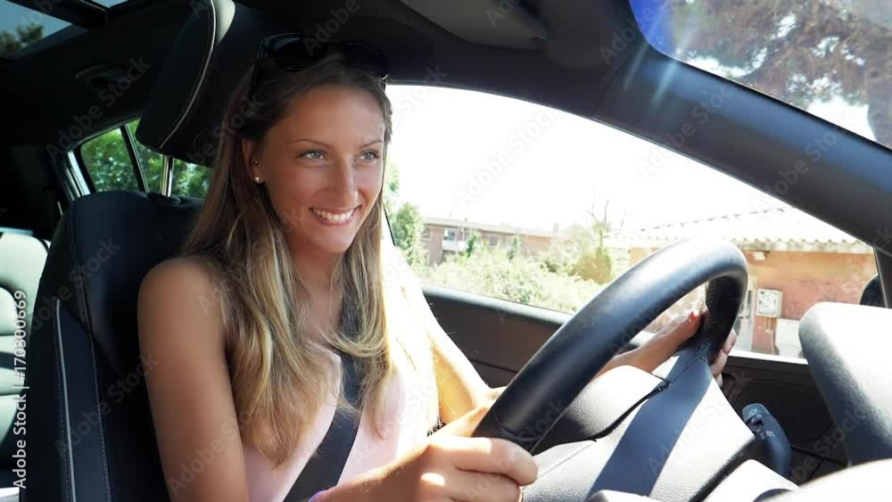 Cute happy blond woman smiling in car while driving super slow motion Cute happy blond woman smiling in car while driving super slow motion
