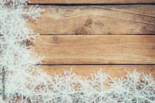 Wooden brown christmas background and white snowflakes with space.