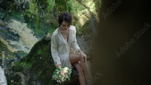 Wallpaper Mural Young woman sitting on a rock near waterfall in lingerie Torontodigital.ca
