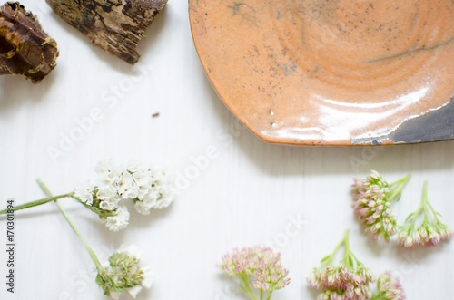 Ceramic set of dishes and cups. Decorative pottery on the wooden table with decorative dried flower