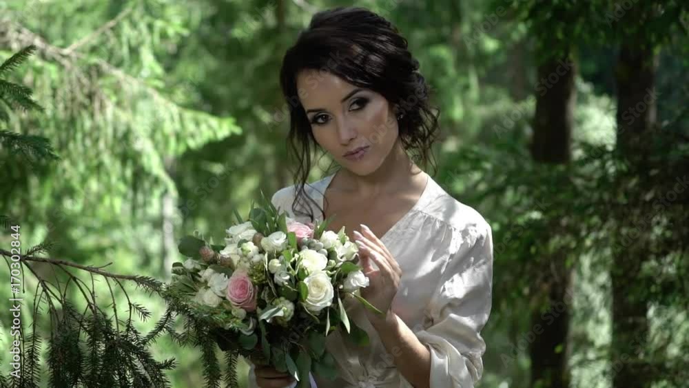 Young woman with bouquet in forest in lingerie Young woman with bouquet in forest in lingerie