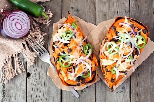 Quadro em tela Baked sweet potatoes stuffed with chicken, vegetables and cheese, above view on