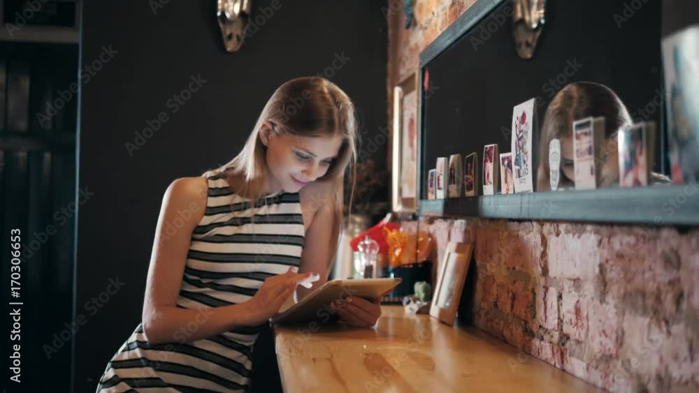 Young female tourist reading map in cafe using tablet and phone to take directions, lost in a big city. Drinking lemonade and having a day off. Young female tourist reading map in cafe using tablet and phone to take directions, lost in a big city. Drinking lemonade and having a day off.