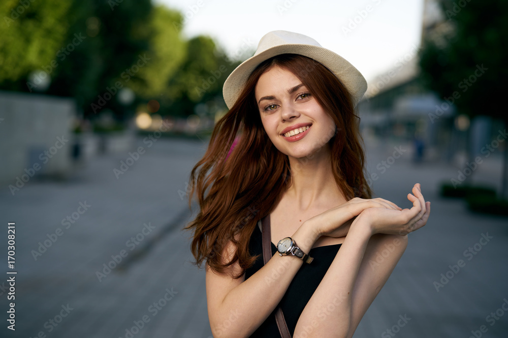 beautiful woman in a hat smiling on the street, portrait
