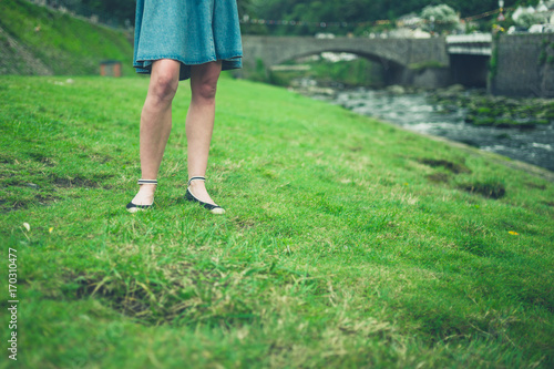 Legs of young woman standing by river