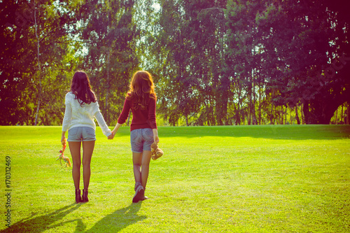Portrait two young beautiful women enjoy life on a nature. Women's friendship as it is. Sisters rest in the park. The concept of friendship and relations among women
