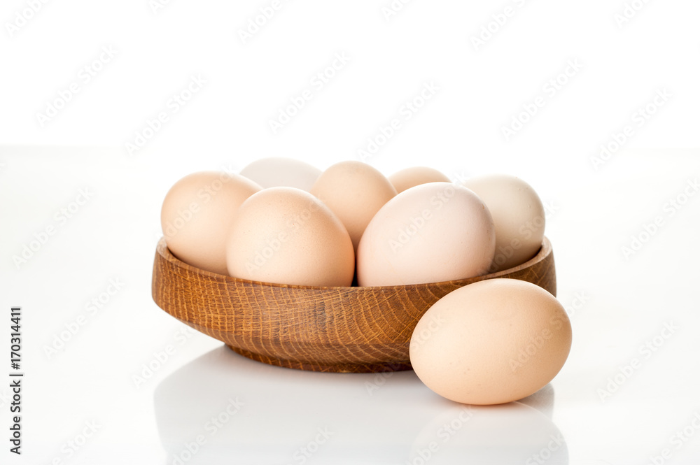 chicken eggs in a wooden plate isolated on white background chicken eggs in a wooden plate isolated on white background