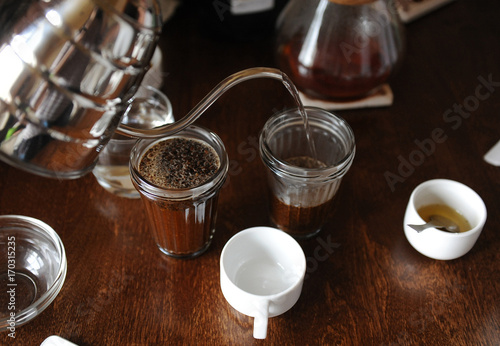The process of tasting cupping. Coffee is brewed in glass cups