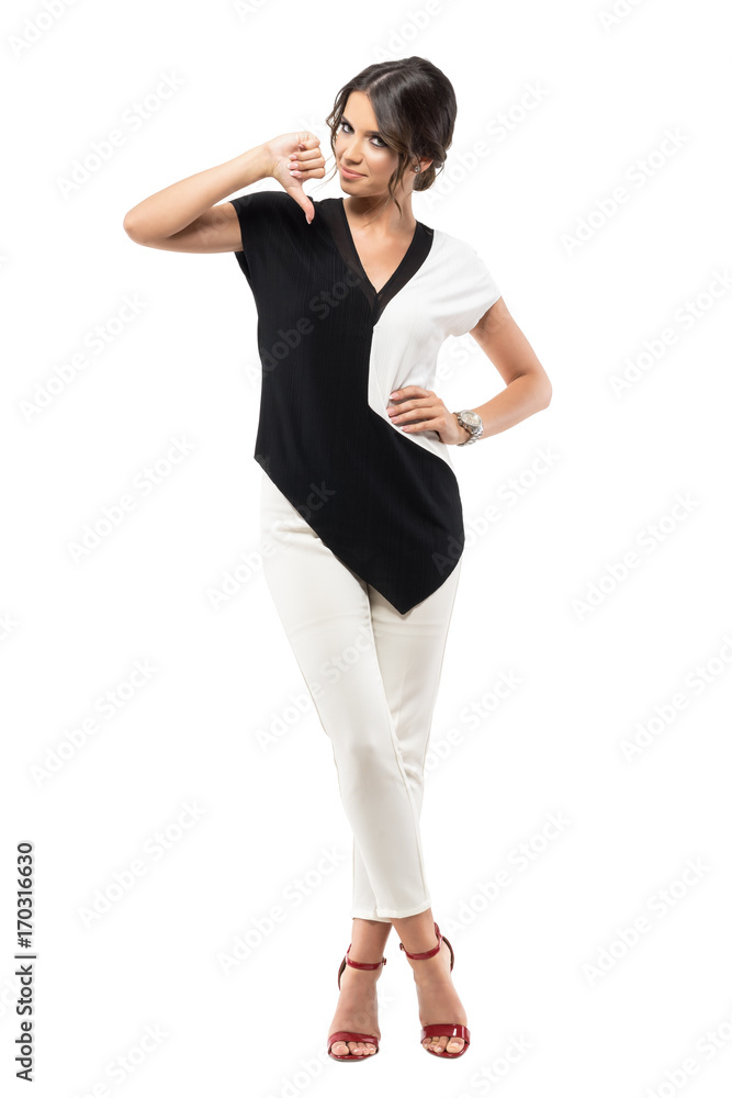 Smiling young business woman showing thumb down hand sign looking at camera. Full body length portrait isolated on white studio background Smiling young business woman showing thumb down hand sign looking at camera. Full body length portrait isolated on white studio background