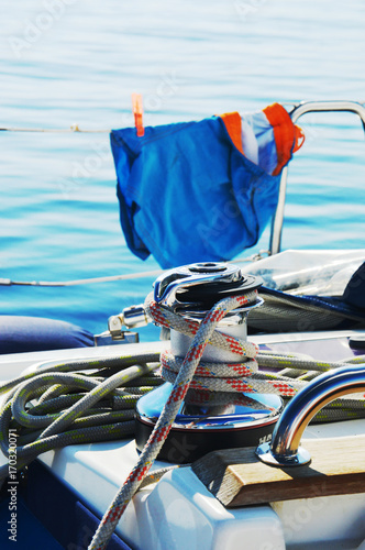 sailboat equipment, winch with blue orange shorts