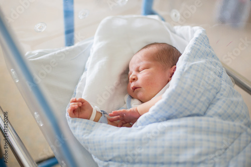 Obraz na plátně Newborn baby laying in crib in prenatal hospital