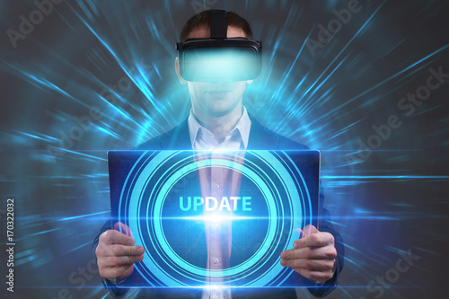 Business, Technology, Internet and network concept. Young businessman working in virtual reality glasses sees the inscription: Update