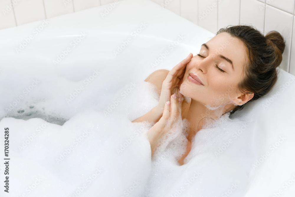 Woman is taking bath with a foam - obrazy, fototapety, plakaty 