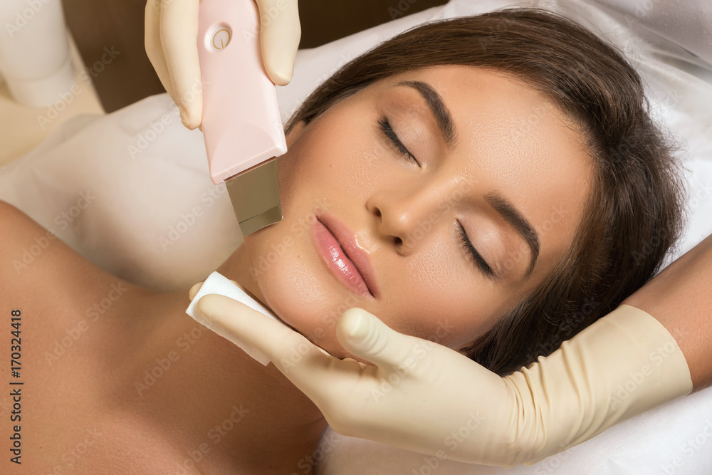 Woman during ultrasonic facial cleansing procedure Woman during ultrasonic facial cleansing procedure