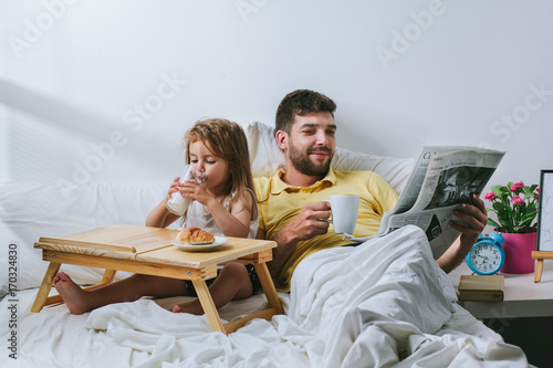Fényképezés Father and daughter having breakfast in bed