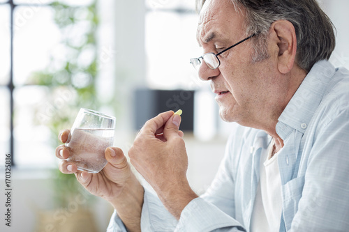 Foto Old man taking a pill