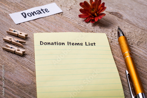 Donation Items List concept on notebook and wooden board