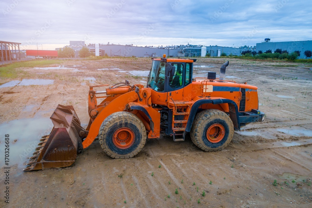 Orange loader bulldozer in the mud