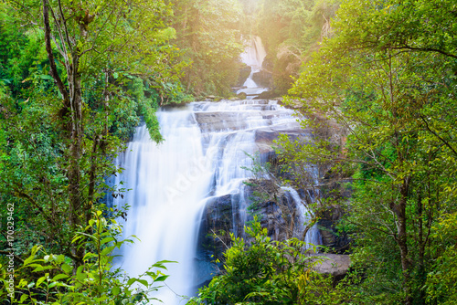 Waterfall in rain forest with flare of sun light at Sirithan waterfall,Chiangmai, Thailand