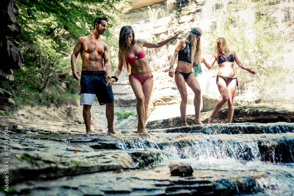 Fototapeta premium Group of friends making excursion in the jungle with waterfall